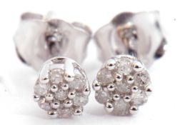 Pair of small diamond stud earrings, a flowerhead design featuring 7 small single cut diamonds in