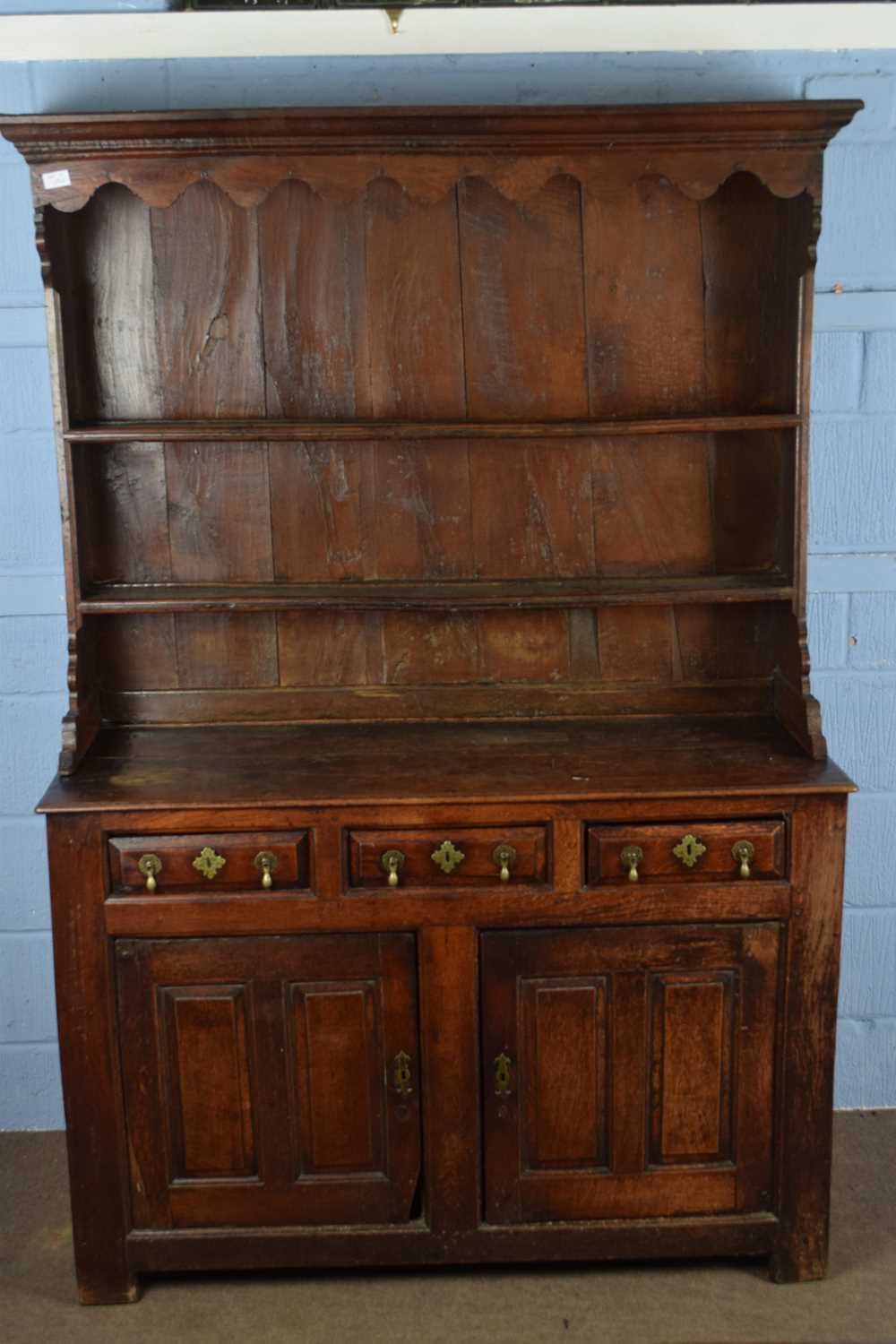 18th century oak dresser, the top section with moulded cornice and two shelves over a base with