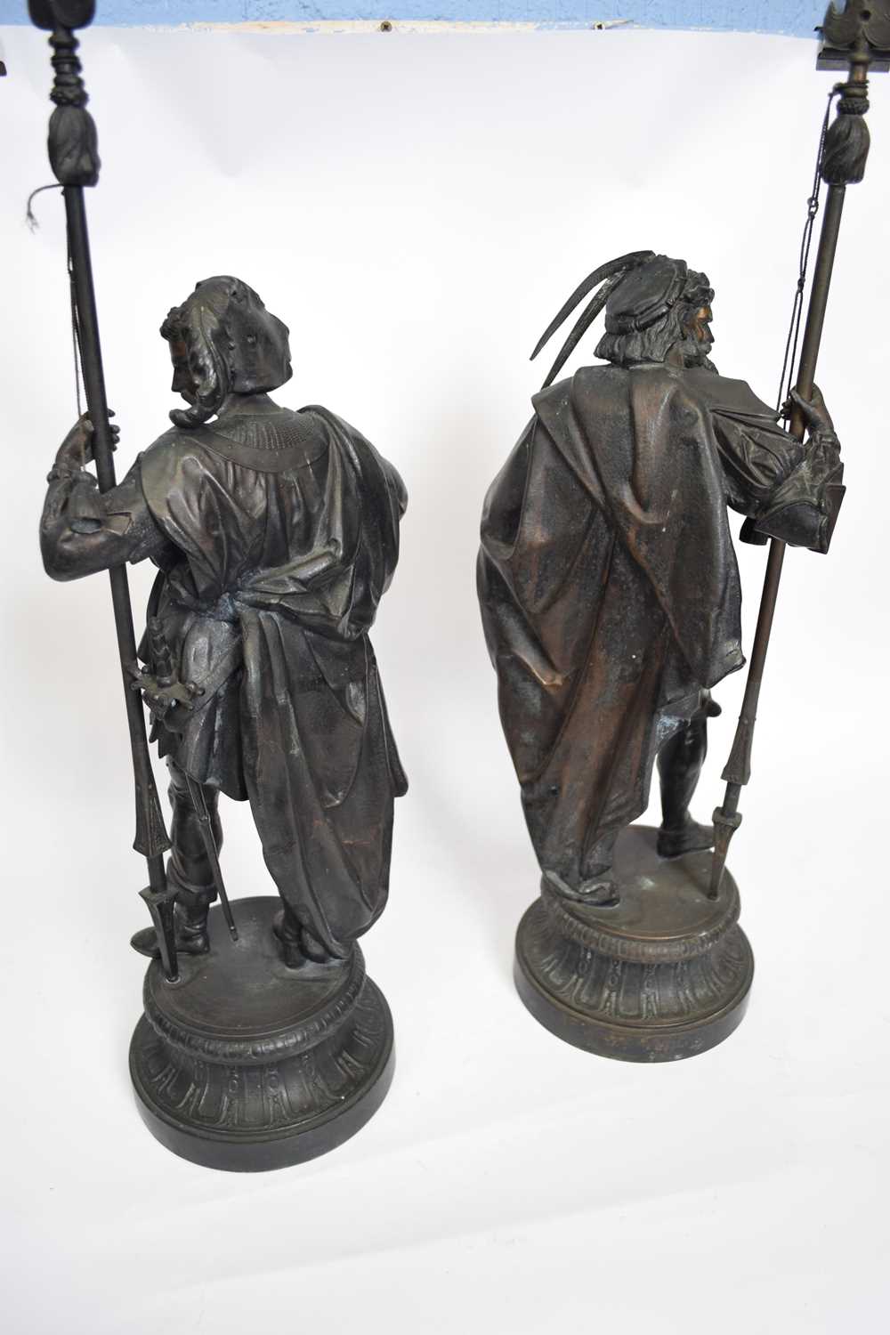 Pair of 19th century bronzed spelter models of lance wielding soldiers, raised on circular plinth