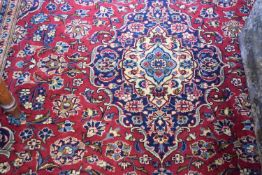Large wool Kashan carpet decorated with central medallion on a blue and red background, 355 x 250cm