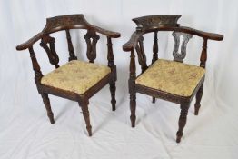 Two Victorian oak corner chairs, the bowed backs profusely carved with foliage detail, with floral