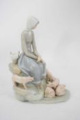 Lladro figure of a girl seated on rockwork surrounded by piglets, 28cm high