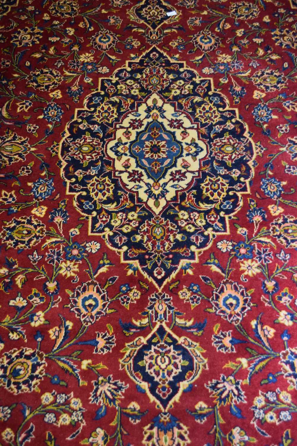 Large Kashan wool floor rug decorated with a large central red and blue panel surrounded by a floral - Image 2 of 3