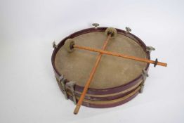 Small circular drum with red stained wooden surround, 31cm wide, together with two drumsticks