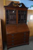 Large George II mahogany bureau bookcase with broken arch pediment over dentil carving and two