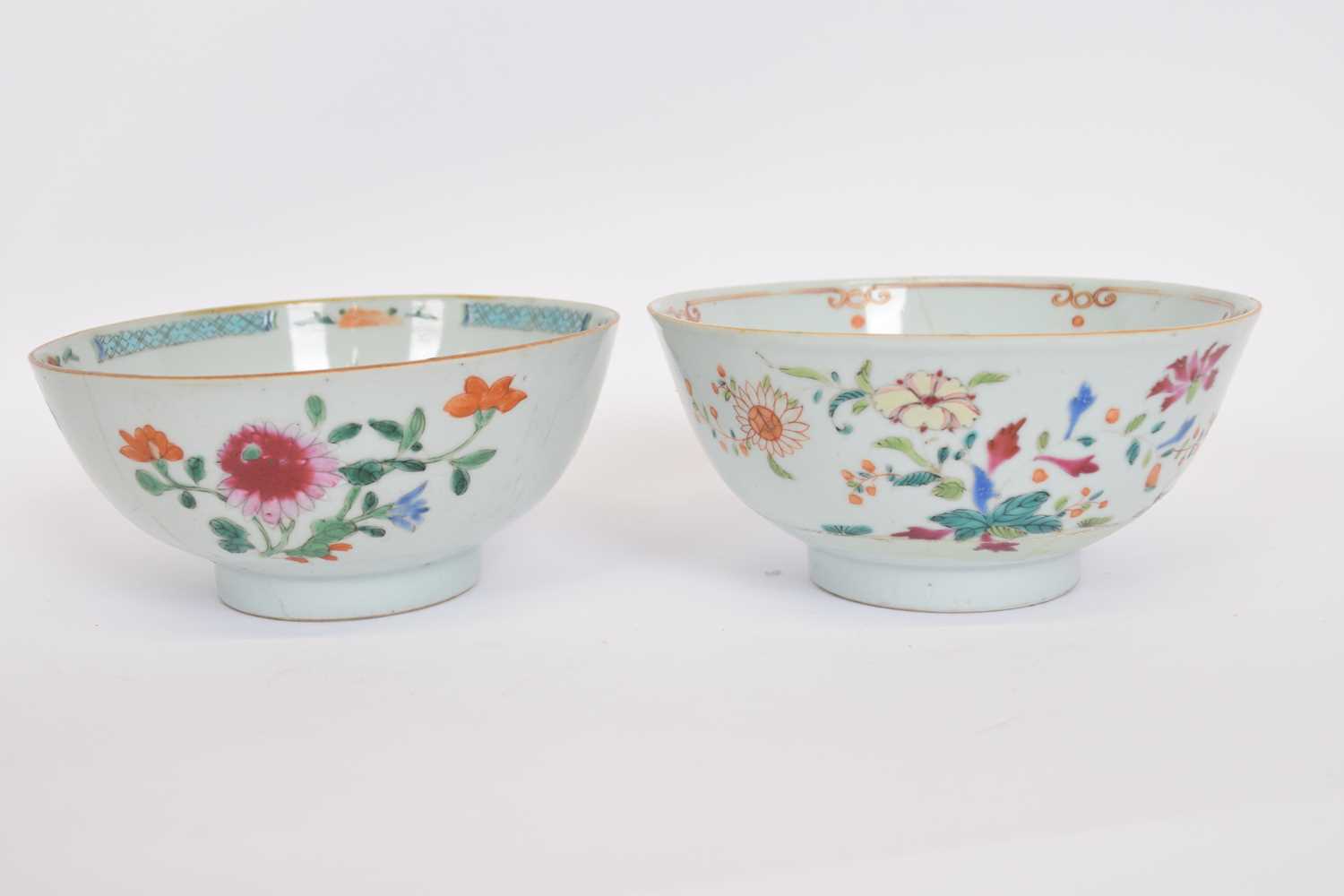 Two Qianlong period bowls with blue and white enamelled designs, mainly of flowers, some in