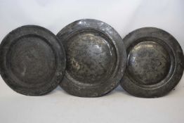 Three 18th century pewter circular plates or chargers, of plain form, 38cm diam