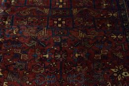 20th century Heriz wool floor rug decorated with stylised floral and geometric design on a