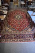 Large Kashan wool floor rug decorated with a large central red and blue panel surrounded by a floral