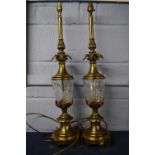 Two impressive brass table lamps with cut glass reservoirs, the lamps 68cm high (2)