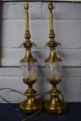 Two impressive brass table lamps with cut glass reservoirs, the lamps 68cm high (2)