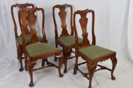 Set of four reproduction dining chairs in the George II style, the shaped backs with carved detail