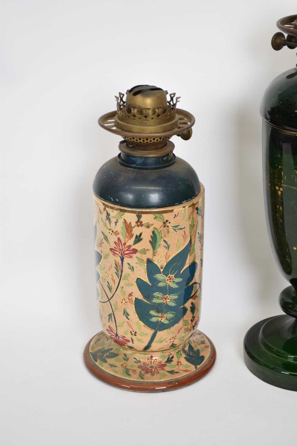 Two 19th century oil lamps, one green glass with gilt design (worn), the other with pottery base