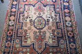 Karajeh runner carpet decorated with large medallions on a red background with geometric border