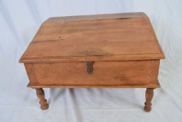 Small hardwood writing box with sloped front, opening to a storage interior raised on small turned