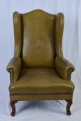 Early 20th century green leather upholstered wing back armchair, 120cm high