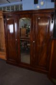 Victorian mahogany wardrobe with triple doors, central mirror and a fitted interior with drawers,