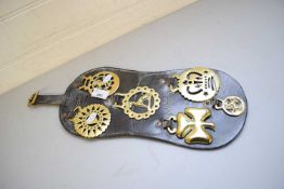 SIX HORSE BRASSES ON LEATHER BACKING