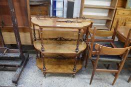 VICTORIAN WALNUT VENEERED THREE TIER WHATNOT WITH TURNED SUPPORTS AND BRASS AND CERAMIC CASTERS,