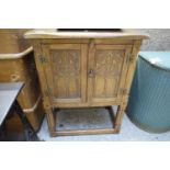 SMALL OAK TWO-DOOR BEDSIDE CABINET WITH GOTHIC CARVED DETAIL