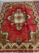 Modern red ground rug with cream, red and green border, central cream motif with green and cream