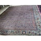 Large old Persian rug with dark blue ground and central panel within a green stylised rectangular
