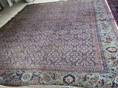 Large old Persian rug with dark blue ground and central panel within a green stylised rectangular