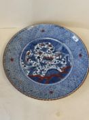 Porcelain circular charger, with all over blue geometric pattern and a central panel, decorated in