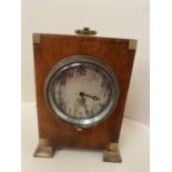 Small mahogany cased mantel clock with winding chord to side of frame. The silvered dial engraved