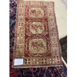 An antique small Persian rug, central red panel, with 3 lozinges, 150 x 89cm (condition - some