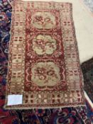 An antique small Persian rug, central red panel, with 3 lozinges, 150 x 89cm (condition - some