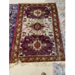 2 rugs - An old Persian rug, with 3 maroon panels within a multi coloured border, 170 x 110cm (