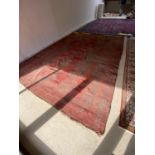 Red ground rug with all over thistle leaf pattern design, cream rectangular border with multi