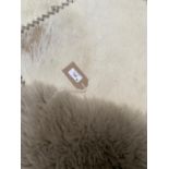 Two contemporary rugs, a grey woolly/sheepskin ; and a contemporary cream and stitched rug