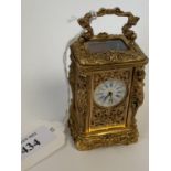 Miniature ornately decorated brass carriage clock with enamel dial. Good condition not tested