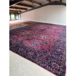 A good quality late C19th very large Sarouk rug, 731 x 450cm with crimson ground and all over floral