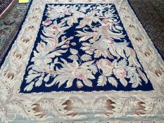 Needlepoint rug, lined, navy central rectangular panel with large flower pattern and light greys