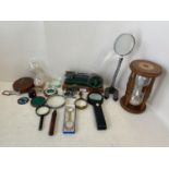 Quantity of magnified glasses, 2 sand timers, 2 small mechanical pumps and 2 vintage leather cased
