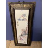 Chinese ceramic screen decorated with a fisherman mounted in a wooden and embossed metal frame,