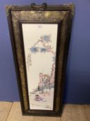 Chinese ceramic screen decorated with a fisherman mounted in a wooden and embossed metal frame,