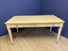 Cream and gilt painted writing table with 3 drawers and tapered reeded legs below a cream