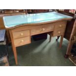 A Limed oak serpentine front dressing table of 5 drawers beneath a plate glass top with curtain rail