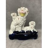 A Staffordshire group model of a poodle with a basket of flowers in its mouth and two pugs 12 cm H