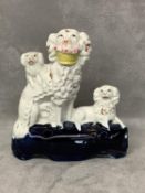 A Staffordshire group model of a poodle with a basket of flowers in its mouth and two pugs 12 cm H