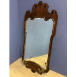 A Regency style wall mirror, set in a scrolling mahogany veneered frame, with a pair of candle