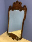 A Regency style wall mirror, set in a scrolling mahogany veneered frame, with a pair of candle