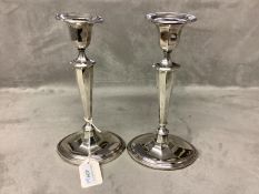 A pair of silver candlesticks oval panelled with loaded bases, by Thomas Bradbury & Sons Sheffield