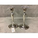 A pair of silver candlesticks oval panelled with loaded bases, by Thomas Bradbury & Sons Sheffield