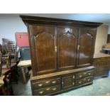C18th oak hall cupboard of 3 panelled doors above a central cupboard flanked by 4 drawers with