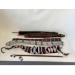 Three early C20th ethnic tribal bead work belts/sashes and two paper umbrellas, and 2 pipes